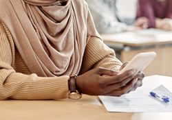 Photo: Woman using her cell phone at a desk