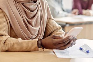 Photo: Woman using her cell phone at a desk